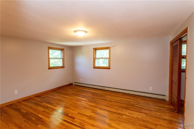 209 Pear Tree Dr, Camillus, NY 13031 - spare room featuring healthy amount of natural light, a baseboard heating unit, and wood finished floors