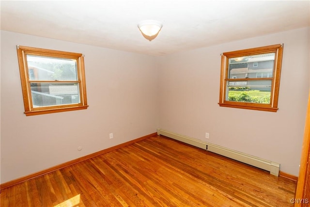 209 Pear Tree Dr, Camillus, NY 13031 - empty room featuring a baseboard radiator, light wood finished floors, and plenty of natural light