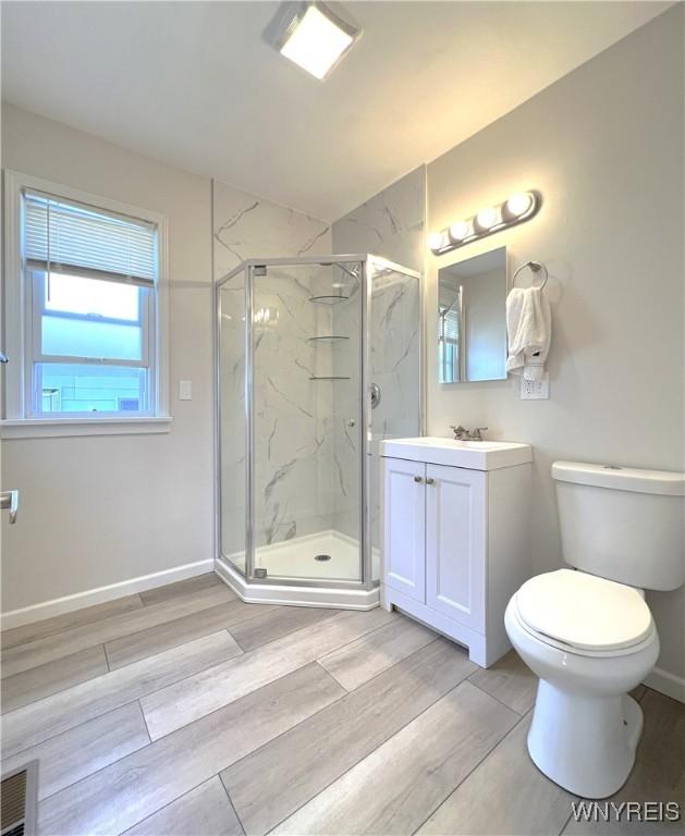 42 Argus St, Buffalo, NY 14207 - bathroom featuring vanity, a marble finish shower, and wood finished floors