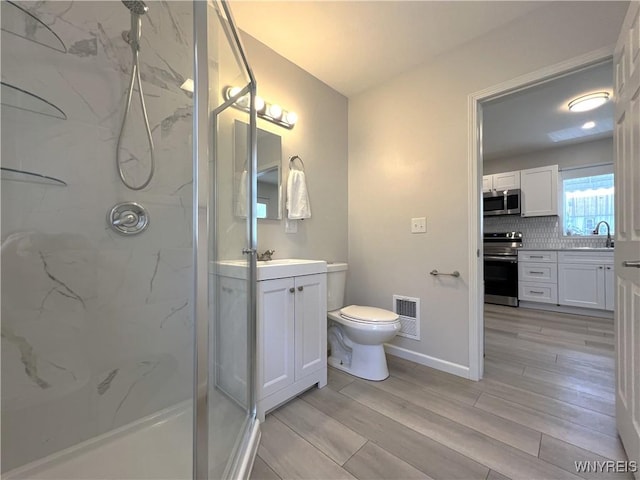 42 Argus St, Buffalo, NY 14207 - bathroom with a marble finish shower, vanity, and wood finished floors