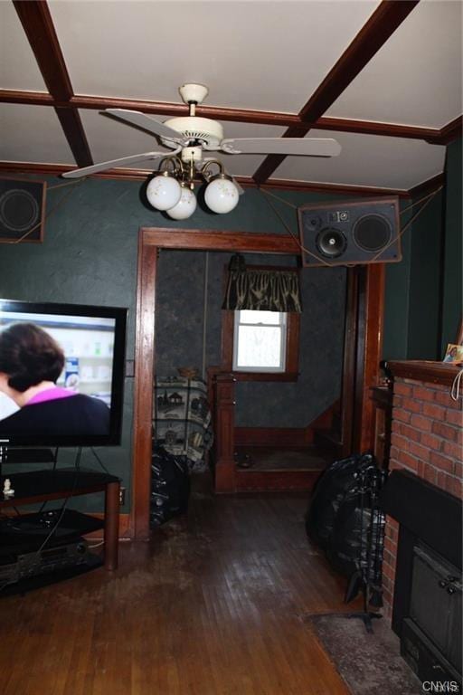 interior space featuring ceiling fan, dark wood-type flooring, and a brick fireplace