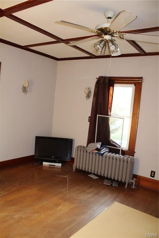 unfurnished room with ceiling fan, dark wood-type flooring, and radiator