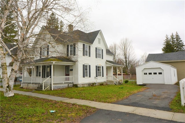 view of front of house with a front yard, covered porch, an outdoor structure, and a garage