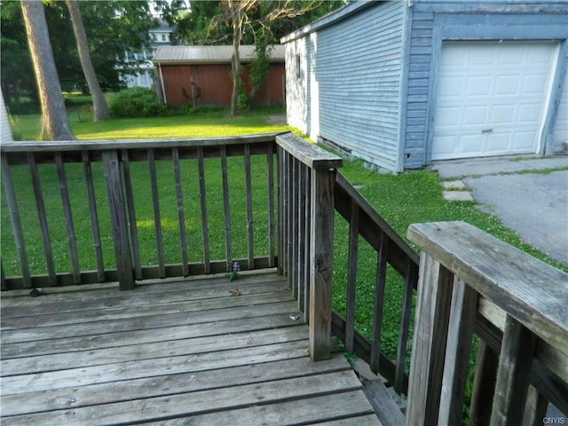 deck with an outdoor structure, a yard, and a garage