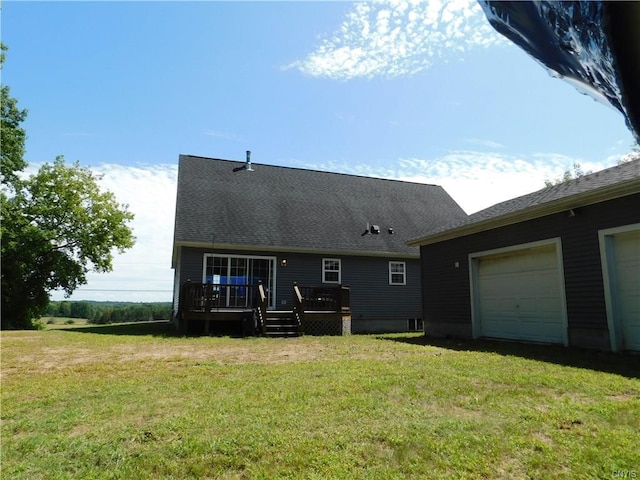 back of property featuring a wooden deck, a garage, and a yard