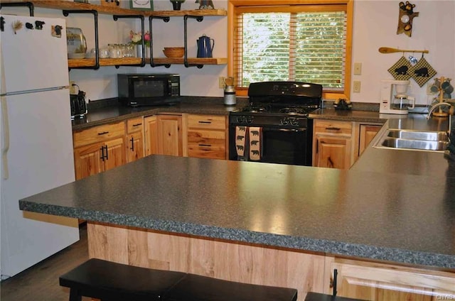 kitchen with sink, light brown cabinetry, and black appliances