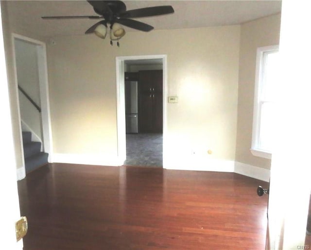 spare room with dark wood-type flooring and ceiling fan