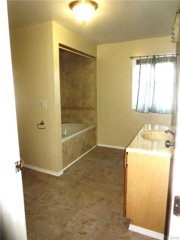 bathroom with tile floors, vanity, and tiled shower / bath