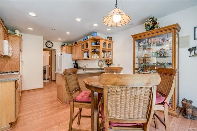 dining room with light hardwood / wood-style floors and sink