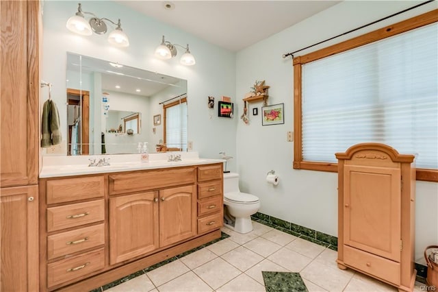 bathroom with toilet, double vanity, and tile flooring