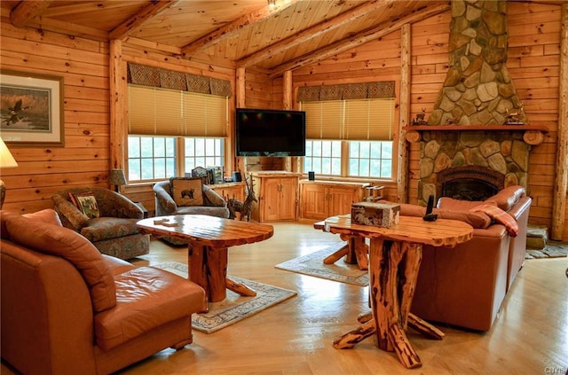 living room with lofted ceiling with beams, wooden ceiling, a fireplace, and light hardwood / wood-style flooring