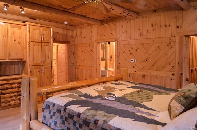 bedroom with beam ceiling, wood ceiling, wood walls, and light wood-type flooring