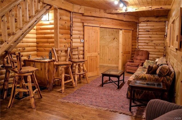 interior space featuring rustic walls, hardwood / wood-style floors, wood ceiling, and sink