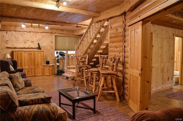 living room with wood ceiling, beam ceiling, log walls, and hardwood / wood-style flooring