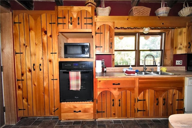 kitchen featuring black oven, dishwashing machine, and sink