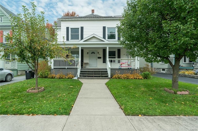 view of front facade with a front yard and covered porch