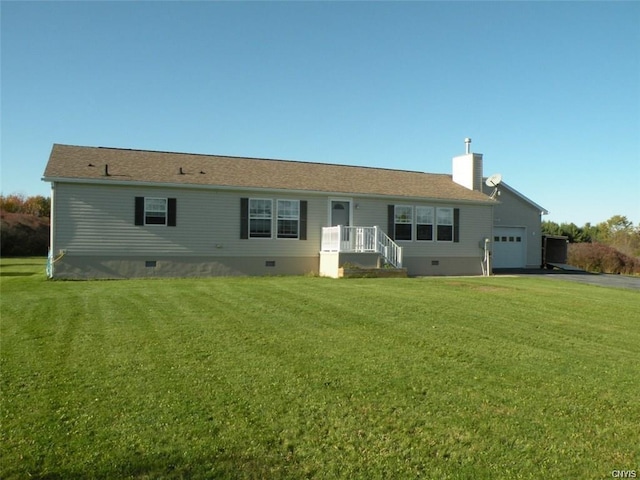 rear view of property featuring a lawn and a garage