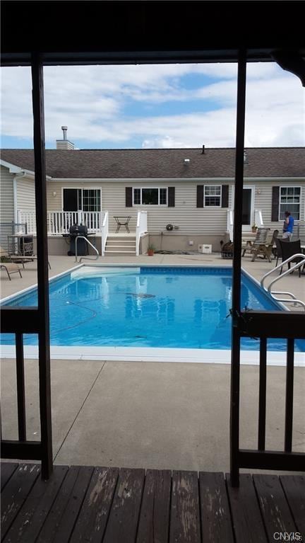 view of pool with a patio and a wooden deck