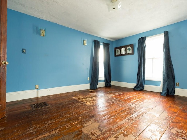 unfurnished room with dark wood-type flooring