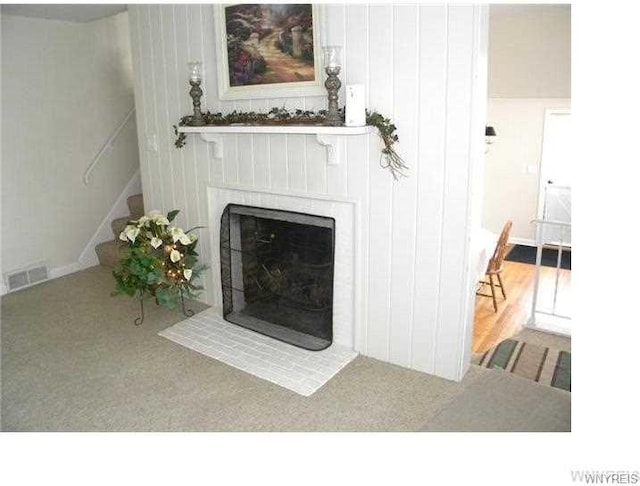 unfurnished living room featuring carpet flooring and a fireplace