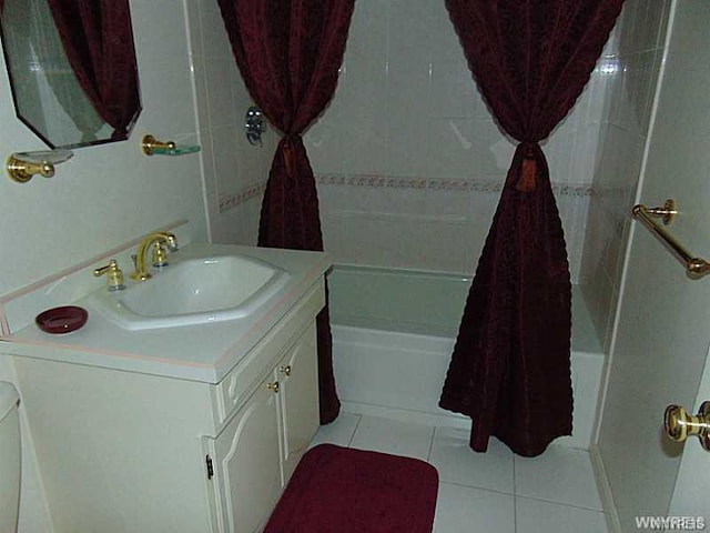 bathroom with tiled shower / bath combo, oversized vanity, and tile floors