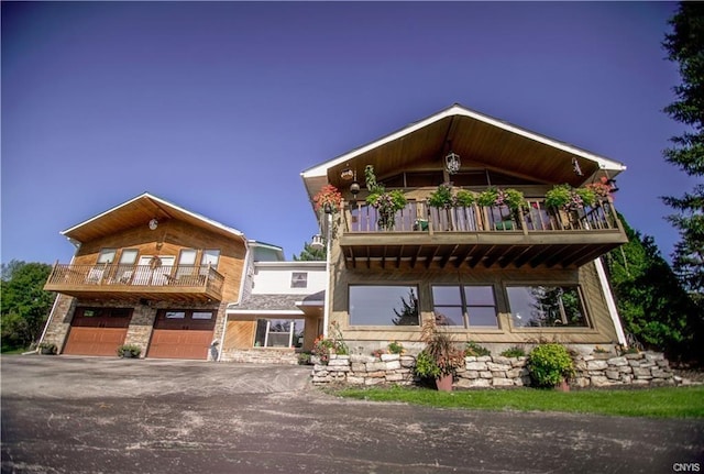 view of front of property featuring a balcony and a garage