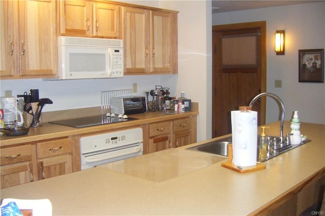 kitchen with white appliances, sink, and light brown cabinetry