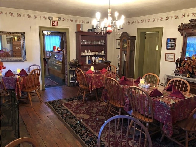 dining space featuring ornamental molding, dark hardwood / wood-style floors, and an inviting chandelier