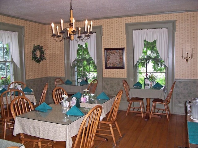 dining area featuring an inviting chandelier, dark hardwood / wood-style flooring, and a textured ceiling