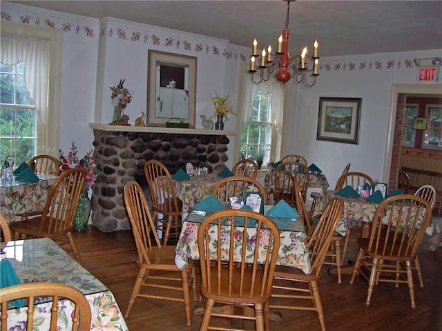 dining space with a notable chandelier, ornamental molding, and dark hardwood / wood-style floors