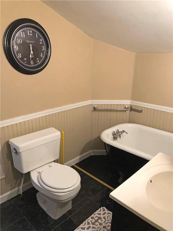 bathroom with toilet, tile flooring, a washtub, and vanity