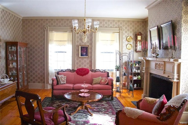 living room with a notable chandelier, a wealth of natural light, ornamental molding, and light hardwood / wood-style floors