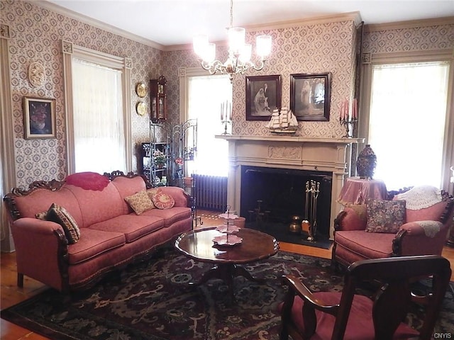 living room with a healthy amount of sunlight, wood-type flooring, a chandelier, and radiator