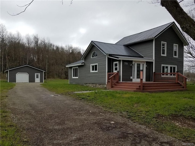 view of front of home featuring a front yard, an outdoor structure, a garage, and a wooden deck