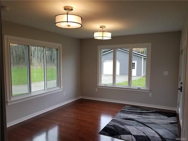 unfurnished bedroom with dark hardwood / wood-style flooring and multiple windows