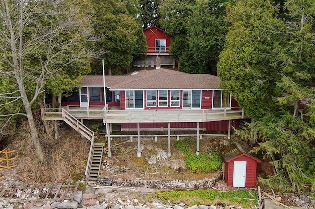 rear view of property featuring a storage unit