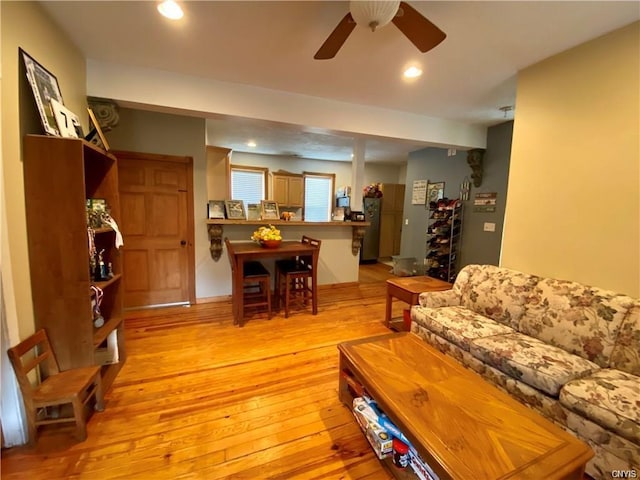 living room featuring ceiling fan and light hardwood / wood-style flooring