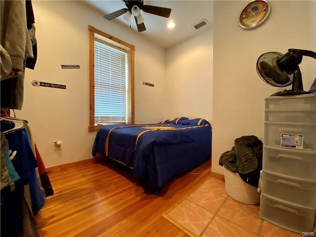 bedroom with ceiling fan, multiple windows, and light wood-type flooring