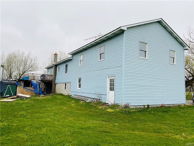 back of house featuring a deck and a yard