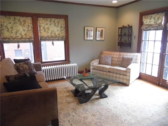 living room with radiator heating unit, ornamental molding, and hardwood / wood-style flooring