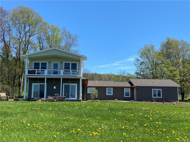 view of front of house with a balcony and a front yard