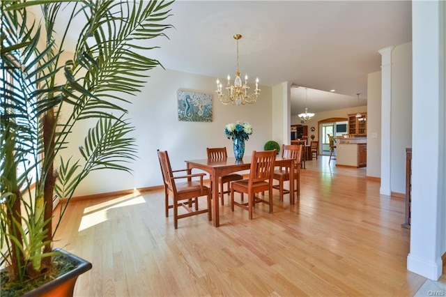 dining space with a notable chandelier and light hardwood / wood-style floors