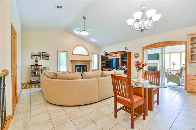 living room with a chandelier, light tile flooring, and vaulted ceiling