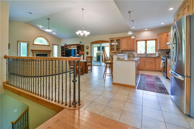 kitchen featuring backsplash, stainless steel appliances, a kitchen breakfast bar, and pendant lighting