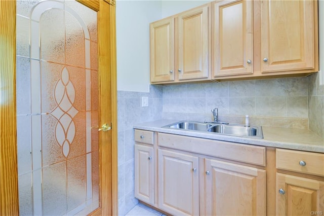 kitchen with tile walls, sink, backsplash, light tile flooring, and light brown cabinets