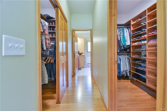 walk in closet with light hardwood / wood-style floors