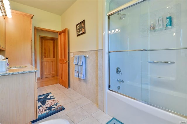 bathroom featuring tile flooring, vanity, and bath / shower combo with glass door