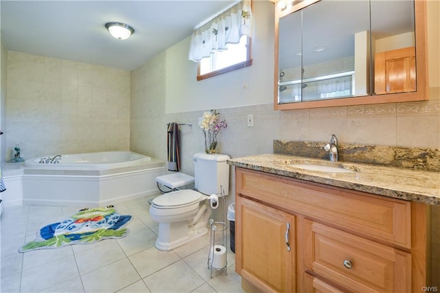 bathroom with tile flooring, toilet, vanity with extensive cabinet space, a bath, and tile walls