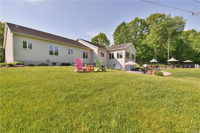 rear view of property featuring a lawn