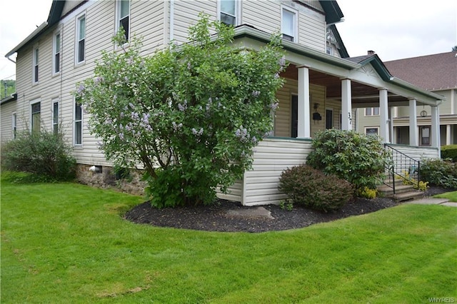 view of home's exterior with a yard and covered porch